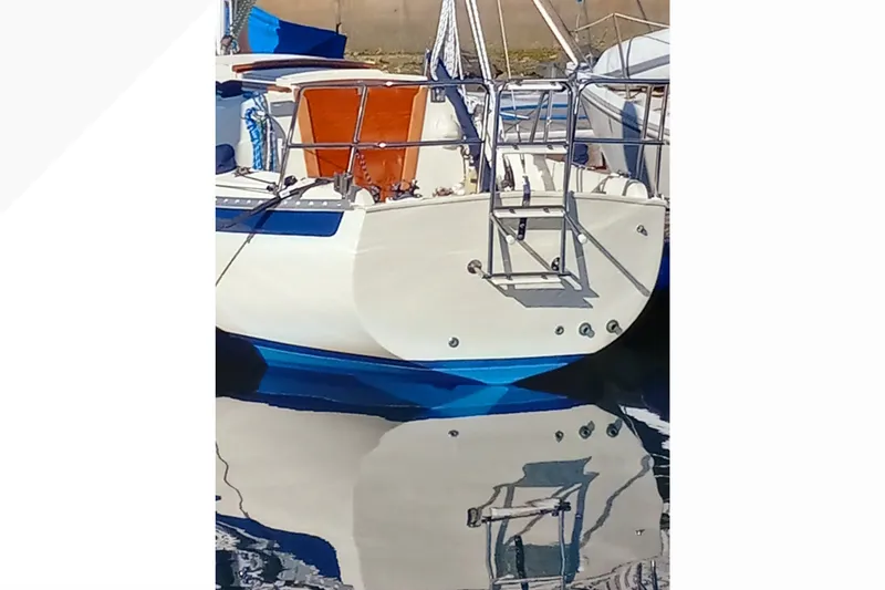 Sailboat Pacific Seacraft Dana 24, 2002 model, docked with reflection on water.