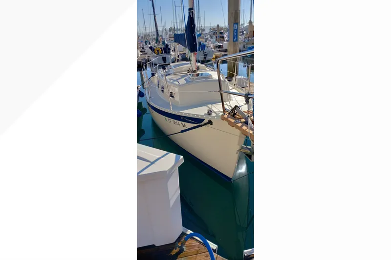 2002 Pacific Seacraft Dana 24 sailboat docked in a marina, sunny day.
