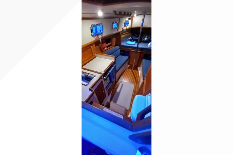 Interior of 2002 Pacific Seacraft Dana 24 sailboat, featuring cozy seating and wooden finishes.