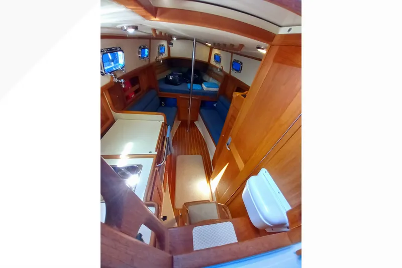 Interior of 2002 Pacific Seacraft Dana 24 sailboat, featuring cozy wooden cabin and seating.