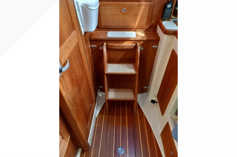 Interior of 2002 Pacific Seacraft Dana 24 sailboat with wooden steps and cabinetry.