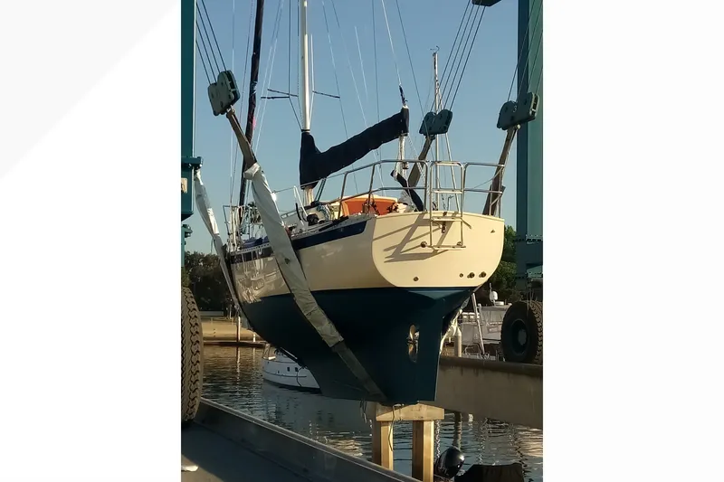 Pacific Seacraft Dana 24 sailboat from 2002 being lifted at a marina.