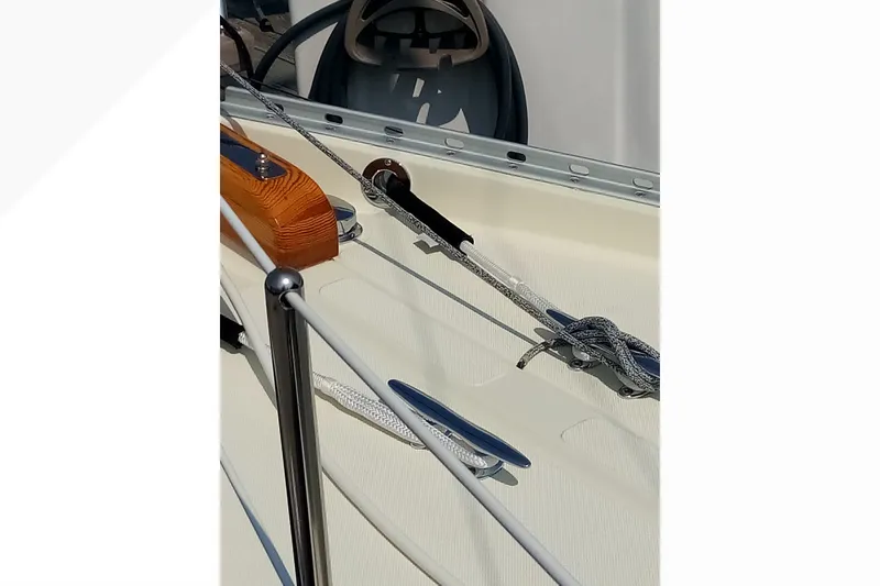 Close-up of 2002 Pacific Seacraft Dana 24 sailboat deck with ropes and steering wheel.