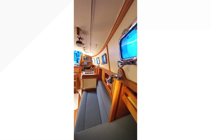Interior of 2002 Pacific Seacraft Dana 24 sailboat, featuring cozy seating and nautical decor.