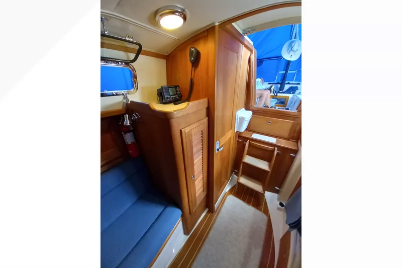 Interior of 2002 Pacific Seacraft Dana 24 sailboat with wooden cabinetry and blue seating.