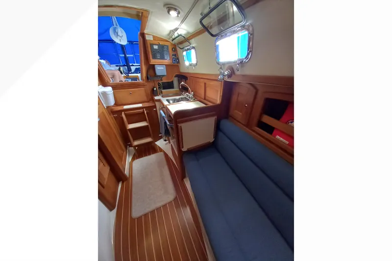 Interior of 2002 Pacific Seacraft Dana 24 sailboat with wood finish and blue seating.