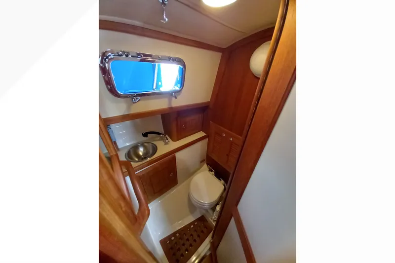 Interior of 2002 Pacific Seacraft Dana 24 sailboat bathroom with wooden cabinetry.