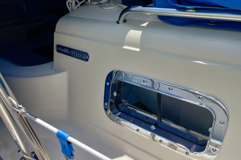 Close-up of a 2002 Pacific Seacraft Dana 24 sailboat, showcasing its sleek design and porthole.