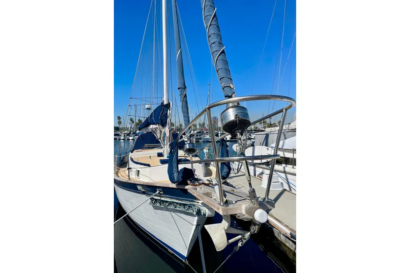1978 Downeast 38 sailboat docked, featuring blue sails and polished deck.