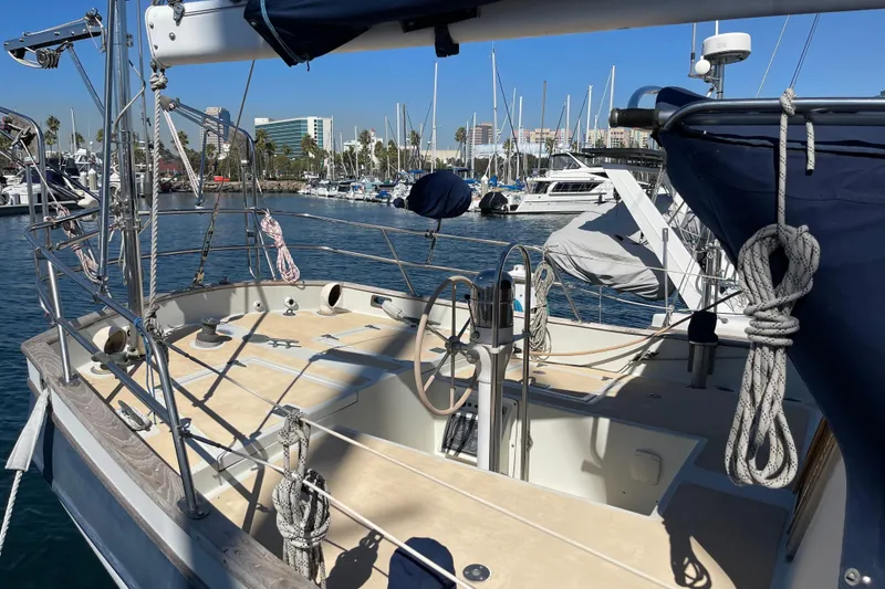 1978 Downeast 38 sailboat docked in marina, featuring spacious deck and rigging.