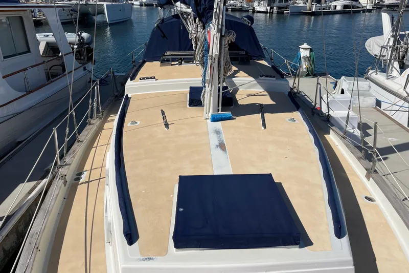 1978 Downeast 38 sailboat deck view in marina, featuring clean lines and blue accents.