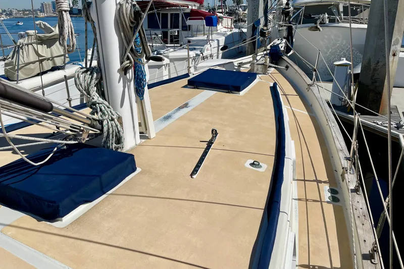 1978 Downeast 38 sailboat deck with ropes and blue cushions at marina.