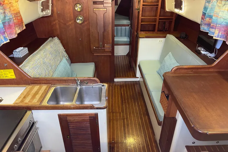 1978 Downeast 38 yacht interior with wood finish, kitchenette, and seating area.