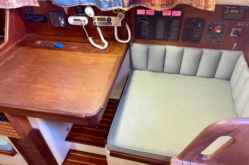 1978 Downeast 38 sailboat interior with navigation station and cushioned seating area.