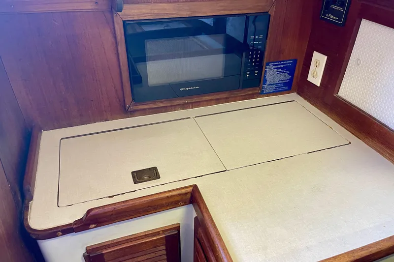 1978 Downeast 38 yacht interior with microwave and countertop in wooden cabinetry.