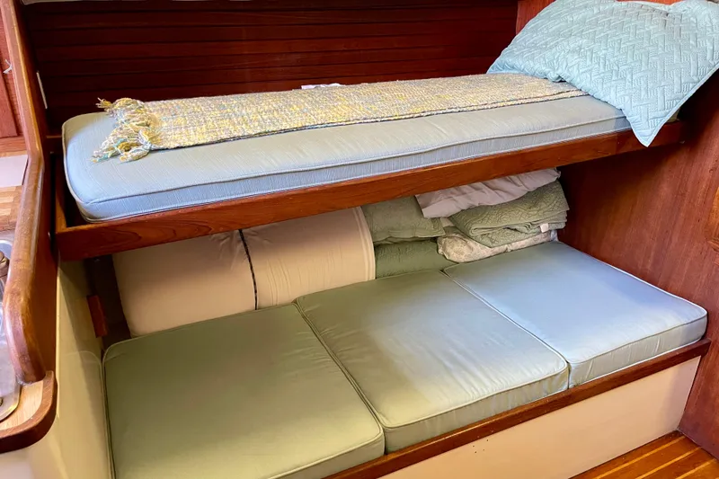 1978 Downeast 38 boat interior with bunk beds and light blue cushions.