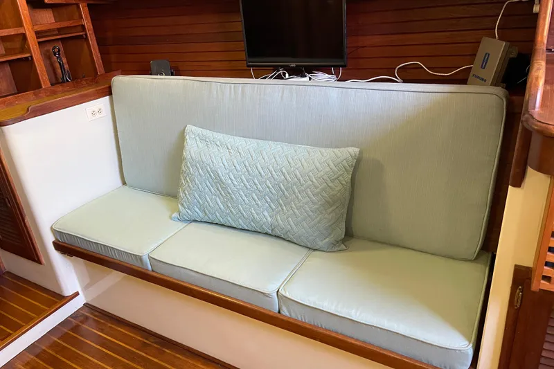 1978 Downeast 38 interior with light blue cushioned seating and wooden accents.
