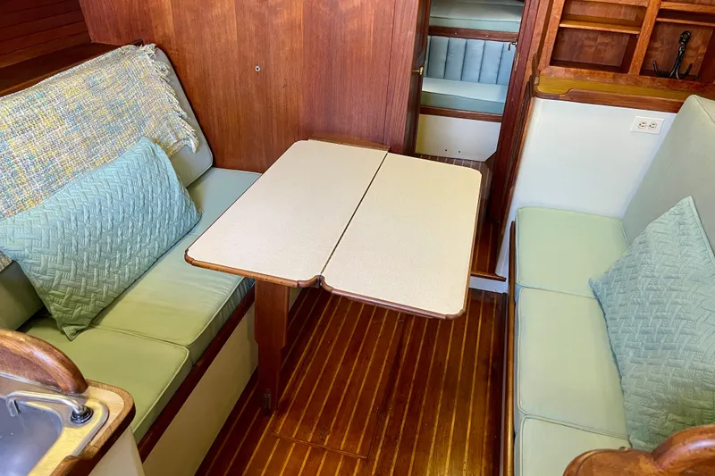 1978 Downeast 38 yacht interior with wooden flooring and cozy seating area.