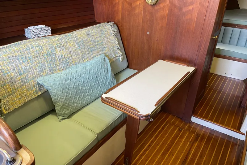 Interior of 1978 Downeast 38 boat with wooden paneling and cozy seating area.