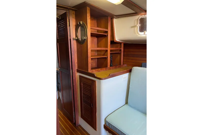 1978 Downeast 38 yacht interior with wooden shelves and seating area.