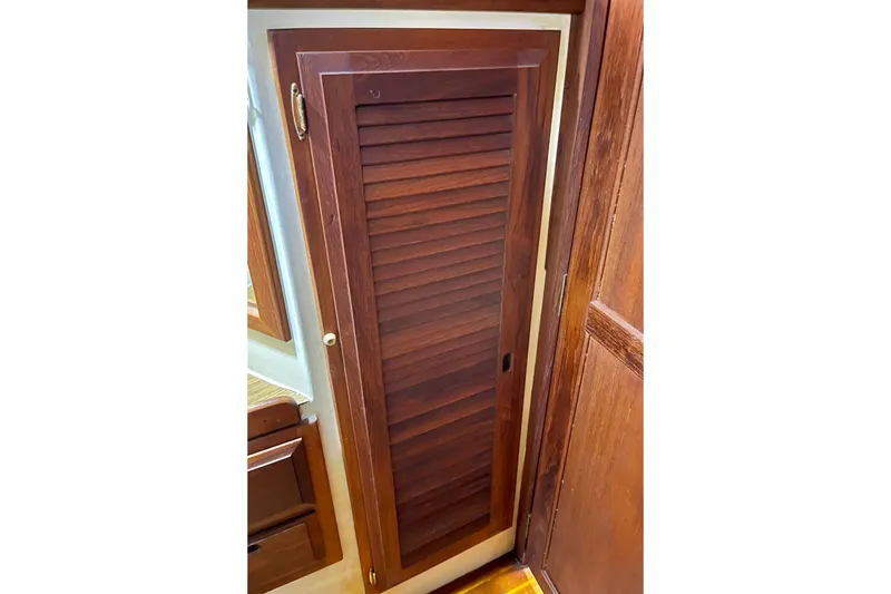 Wooden louvered door inside a 1978 Downeast 38 boat interior.