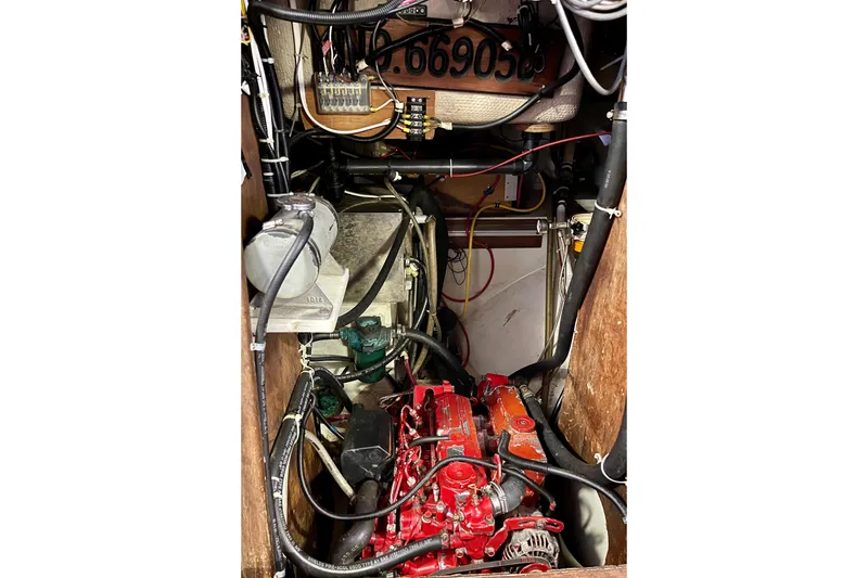 Engine compartment of a 1978 Downeast 38 boat, featuring a red engine and wiring.