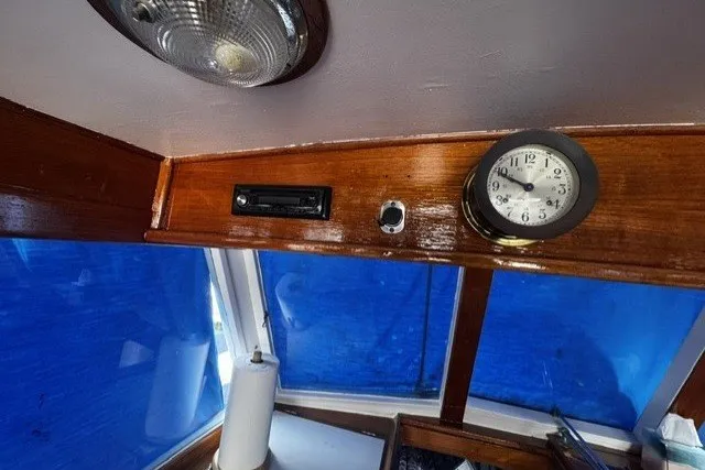Interior of a 1974 Grand Banks 32 Sedan with clock and wooden paneling.