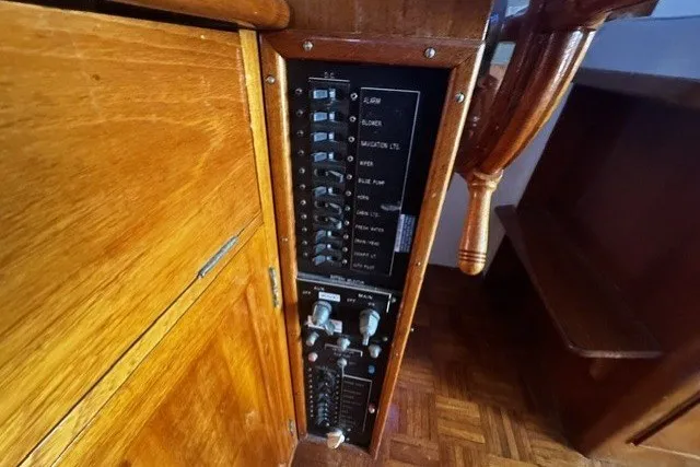Electrical panel of a 1974 Grand Banks 32 Sedan boat with wooden interior.