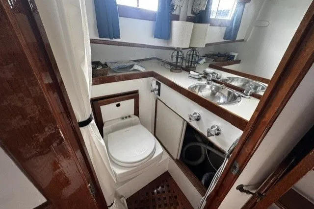 1974 Grand Banks 32 Sedan bathroom with sink, toilet, and wooden accents.