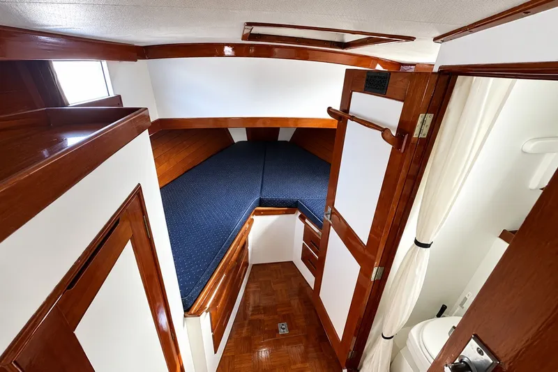 1974 Grand Banks 32 Sedan cabin interior with wooden finish and blue bedding.