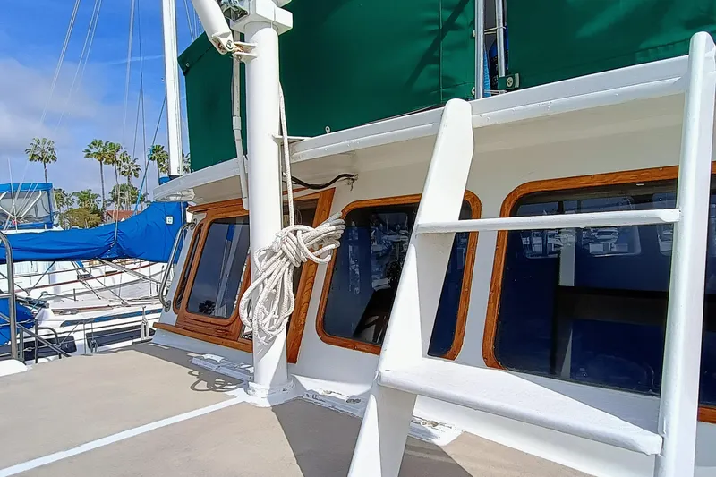 1978 Californian LRC yacht with green canopy and wooden window frames docked at marina.
