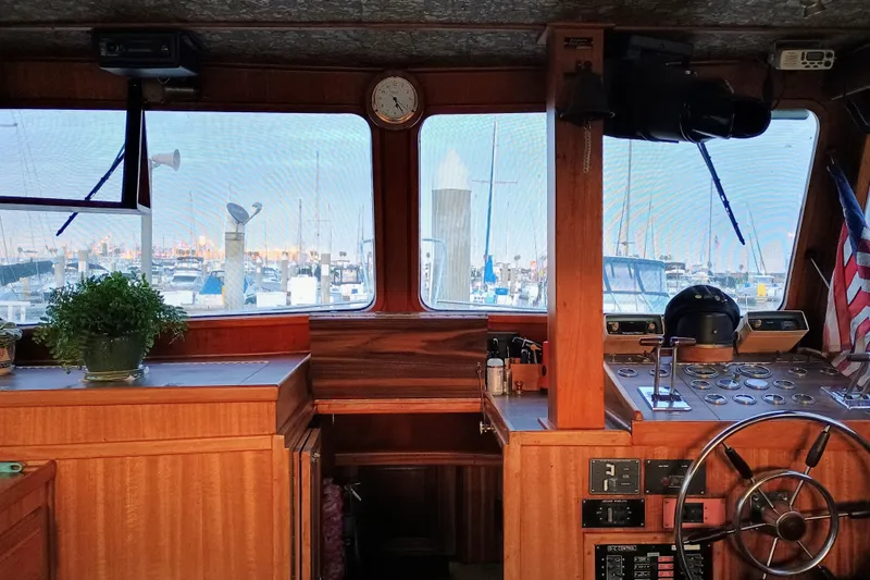 1978 Californian LRC boat interior with wooden helm, marina view, and nautical decor.