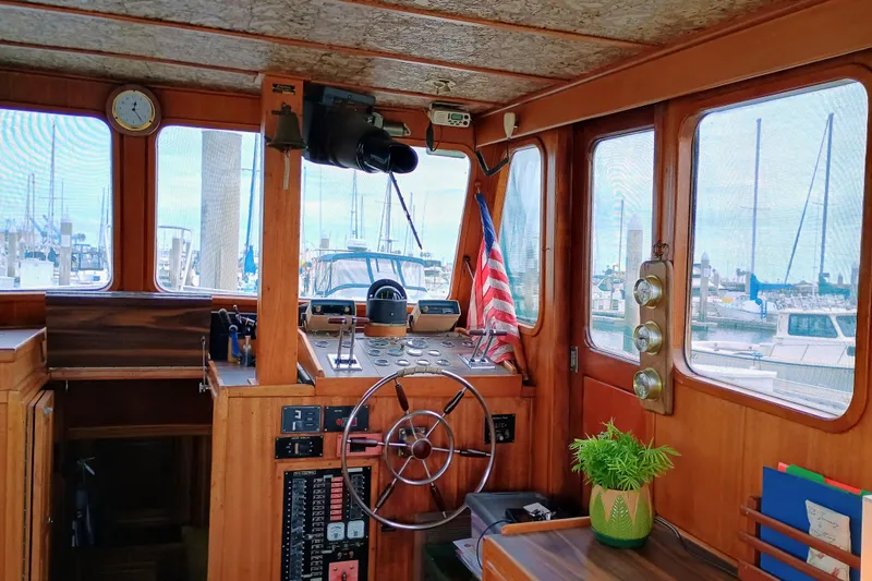 1978 Californian LRC boat interior with wooden helm, American flag, and marina view.