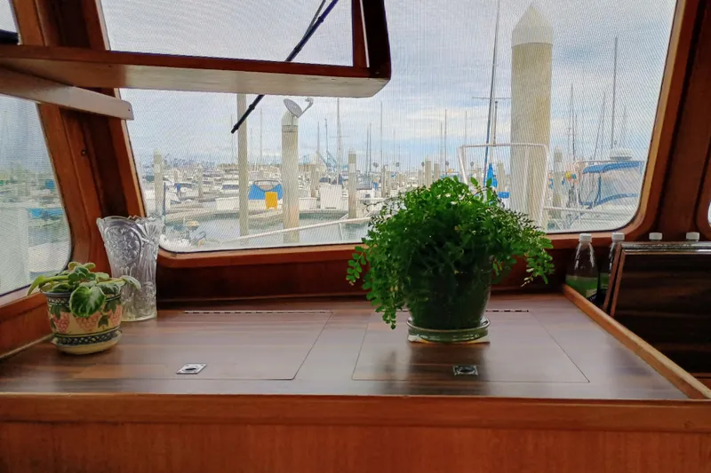Interior of 1978 Californian LRC boat with plants and marina view.