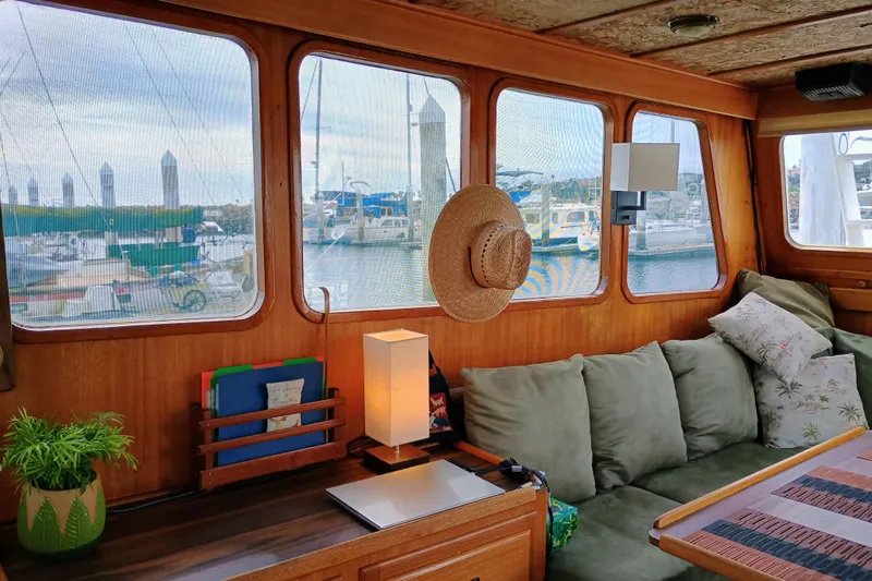 Interior of a 1978 Californian LRC boat with cozy seating and marina view.