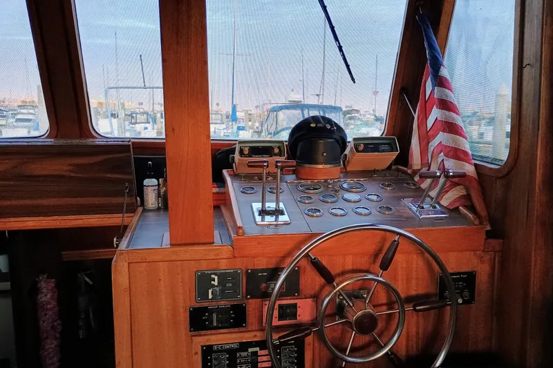 1978 Californian LRC boat helm with wooden dashboard and American flag in marina setting.