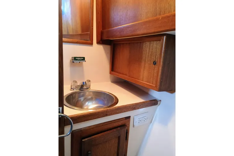 1978 Californian LRC boat bathroom with wooden cabinets and stainless steel sink.