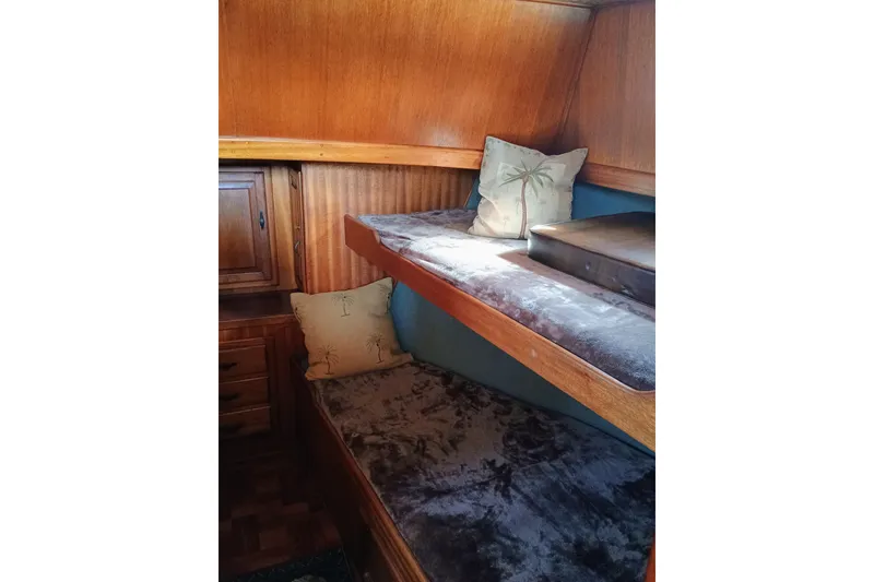 1978 Californian LRC interior with wooden bunk beds and tropical-themed pillows.