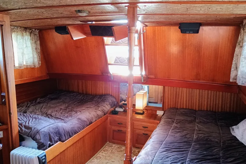 Cozy 1978 Californian LRC boat cabin with twin beds and wooden interior.