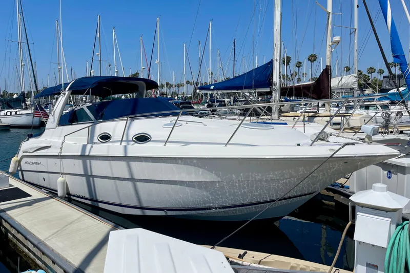 2000 Monterey 302 Cruiser docked at a marina with sailboats in the background.