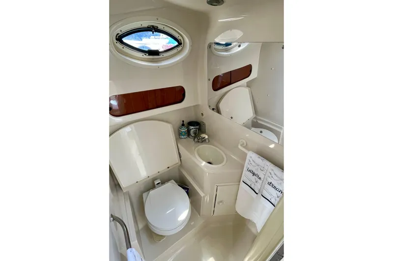 Bathroom interior of a 2000 Monterey 302 Cruiser boat, featuring a compact design.