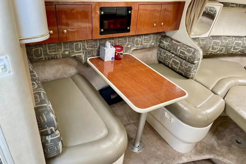 Interior of a 2000 Monterey 302 Cruiser with seating and a wooden table.
