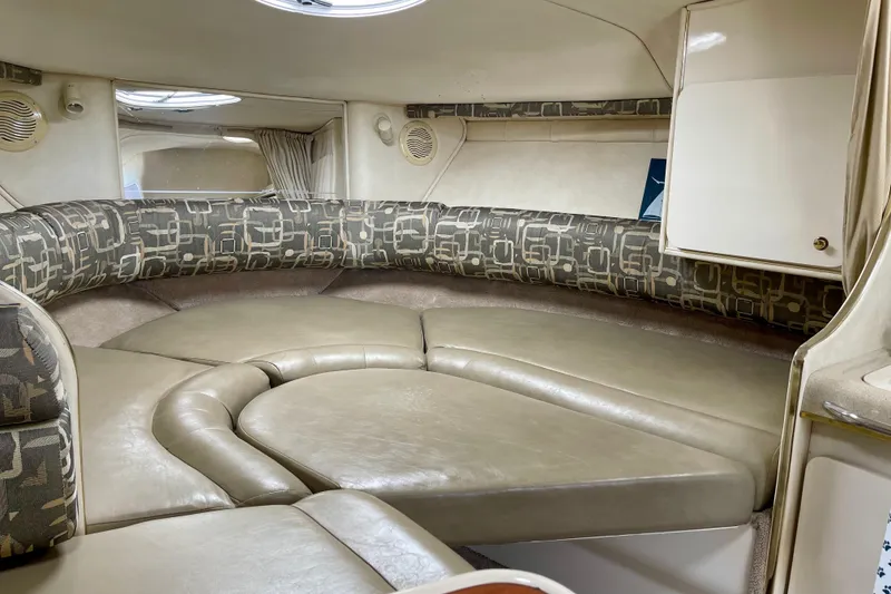 Interior of a 2000 Monterey 302 Cruiser boat with cushioned seating and storage.