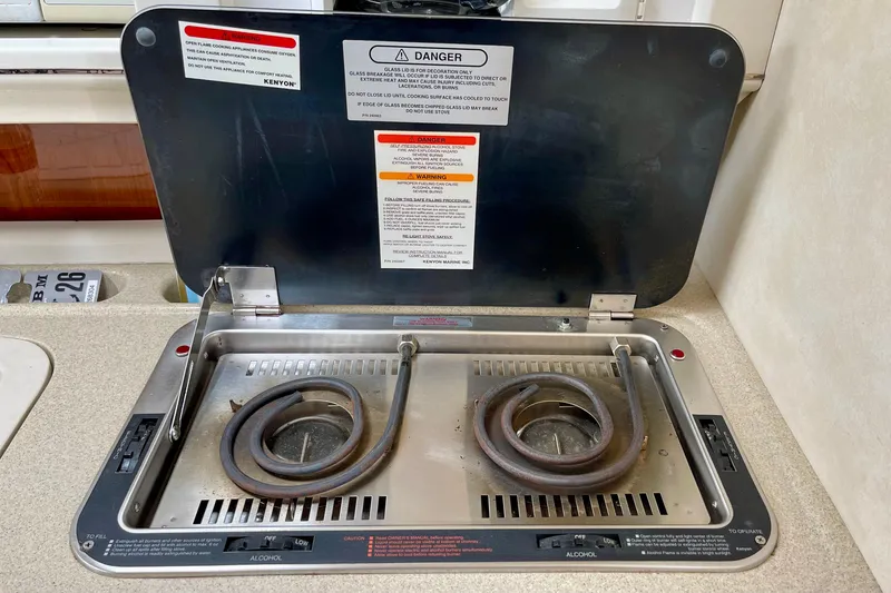 Electric stove in a 2000 Monterey 302 Cruiser boat, featuring dual burners and safety instructions.