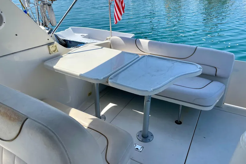 Interior of 2000 Monterey 302 Cruiser with seating and table, overlooking water.