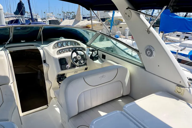 2000 Monterey 302 Cruiser cockpit with steering wheel and gauges, docked at marina.