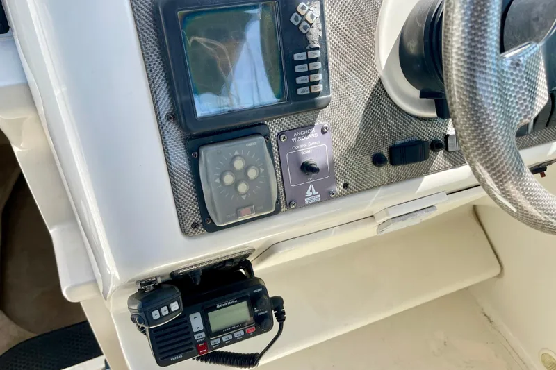 Control panel of a 2000 Monterey 302 Cruiser boat with steering wheel and navigation equipment.
