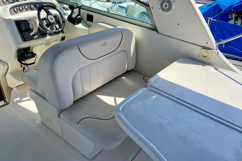 Interior of a 2000 Monterey 302 Cruiser boat with white seating and steering console.