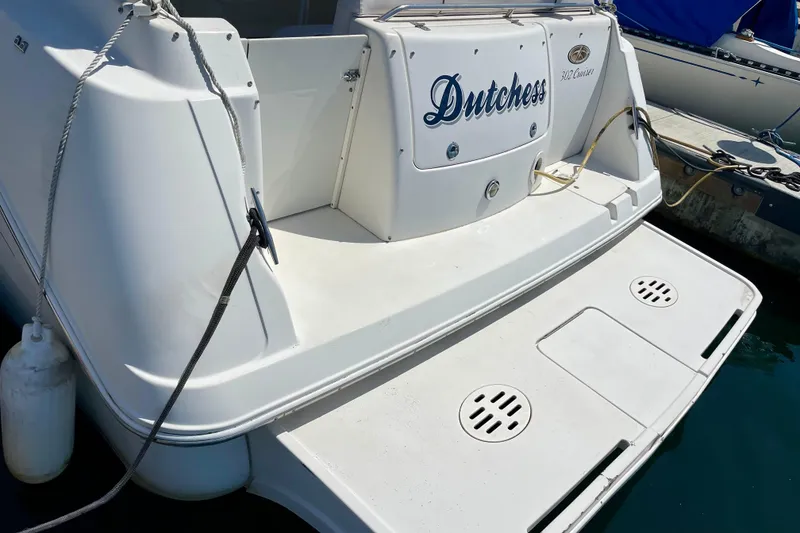 Rear view of a 2000 Monterey 302 Cruiser boat named "Dutchess" docked at a marina.