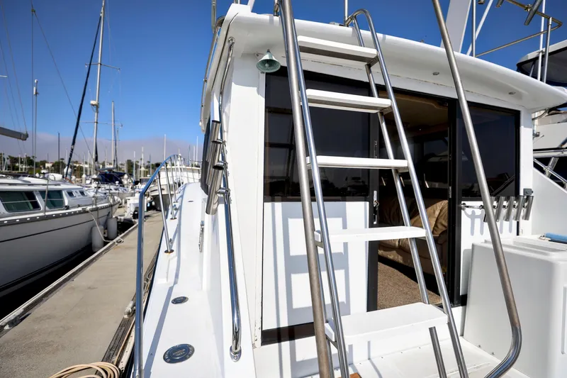 1980 Pacifica 41 Sportfisher yacht docked at marina with ladder and open cabin door.